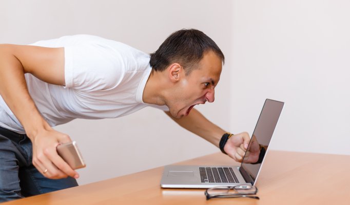 man screaming at laptop frustrated angry vpn services slow internet connection